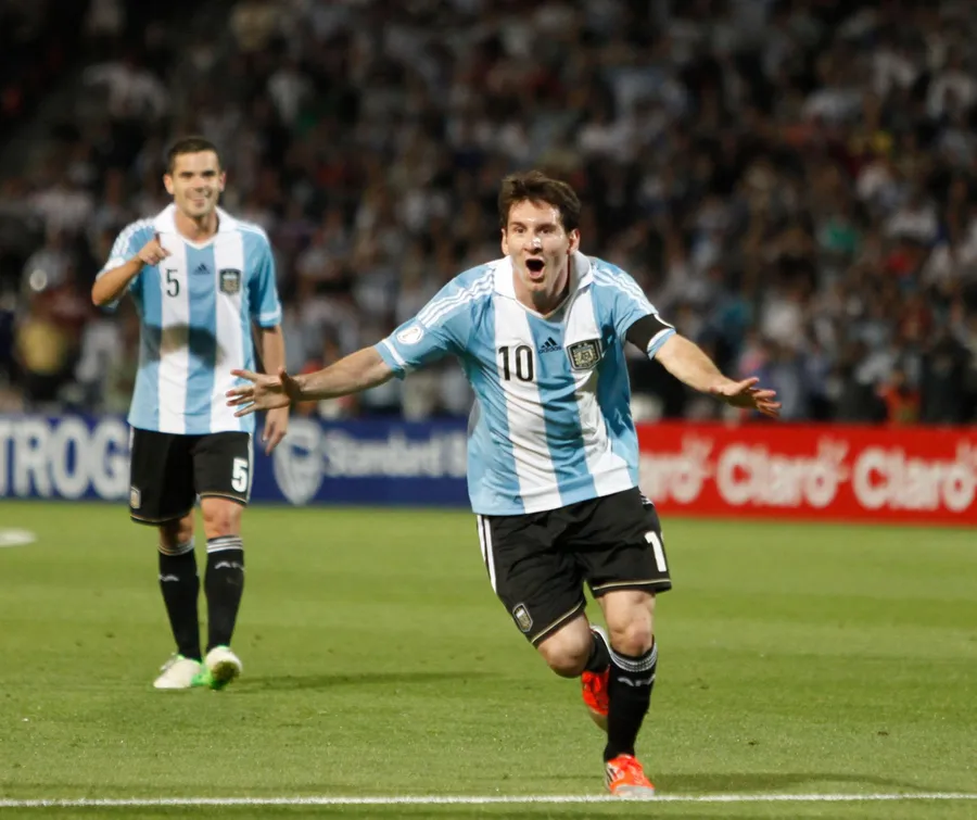 Lionel Messi celebrating a goal in the Argentina number 10 shirt with his arms outstretched